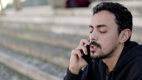 joven serio hablando por teléfono inteligente