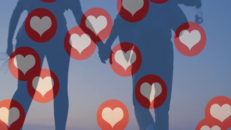 múltiples iconos de corazón flotando contra una pareja tomándose de la mano y corriendo