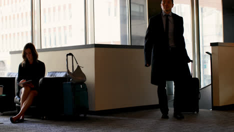 asian businessman walking with luggage in a hotel lobby 4k