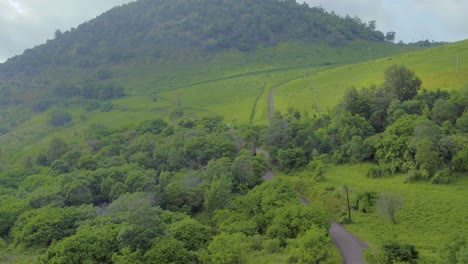 Vista-Aérea-De-La-Isla-Hawaiana-Maui-Y-Su-Paisaje-Verde-Montañoso-Y-Carretera