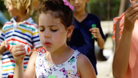 escolar jugando con varita de burbujas en el patio de recreo