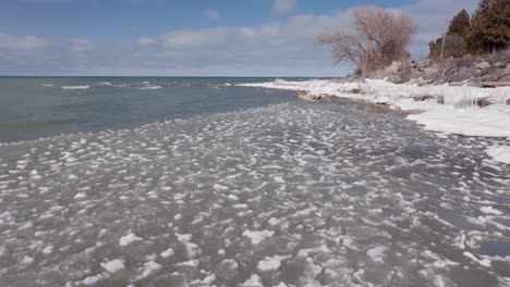 Winter-shore-of-Southampton-with-icy-waters-under-a-clear-blue-sky,-serene-and-chilly-atmosphere,-midday-light