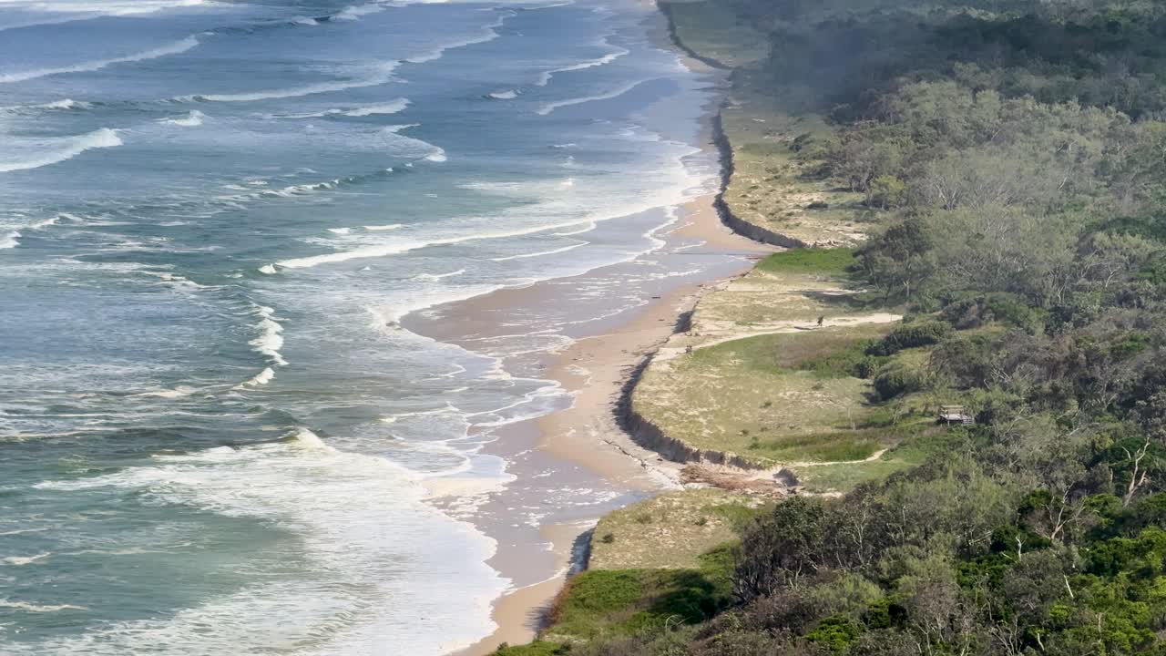 Aerial view of Byron Bay coastline showing erosion and weathering over time with waves impacting the shore