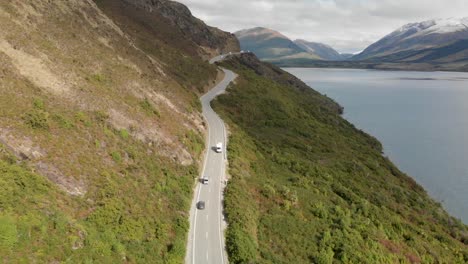 紐西蘭皇后鎮 (queensstown, new zealand) 的kwatipu湖沿岸的山脈上駕駛露營車,背景是新鮮的雪 - - 空中無人機