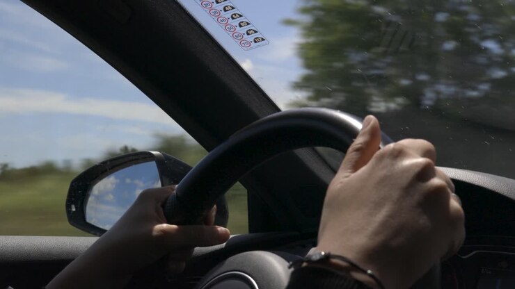 Femme conduisant une voiture, gros plan sur ses mains et le volant