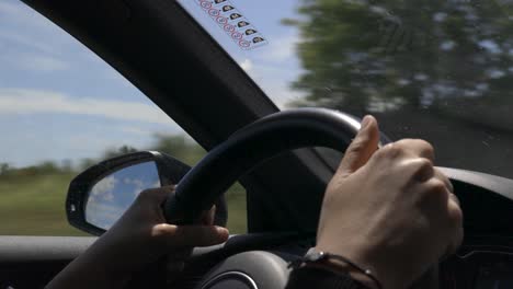 Woman-steering-a-car,-closeup-of-her-Hands-and-the-steering-wheel