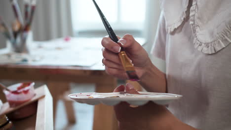 person holding palette with several colors