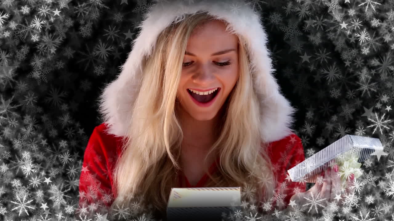 산타 여자가 눈송이와 함께 선물을 열고