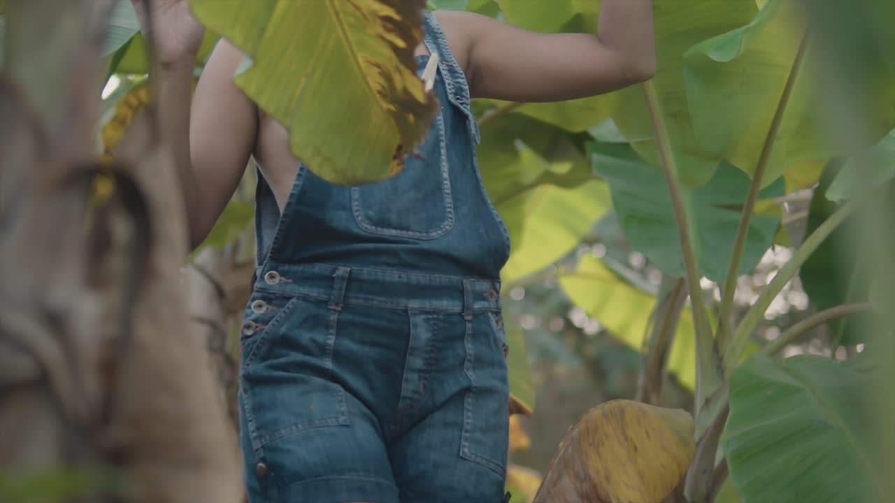 Chica asiática caminando con cuidado por la jungla y explorando los alrededores