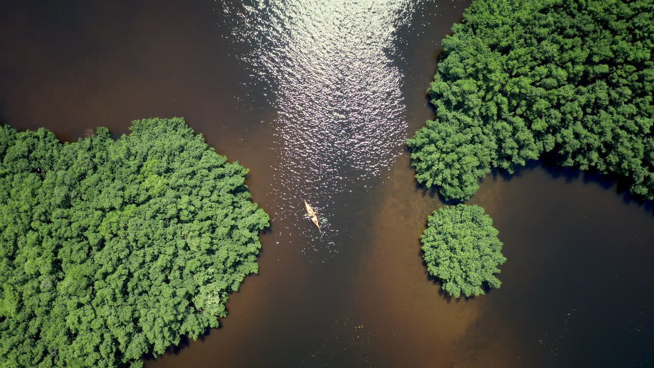 Top Down Aerial View of Lone Kayaker Paddling Across the River in Florida.
Going Down Shot of Female Enjoying Canoeing Alone On River