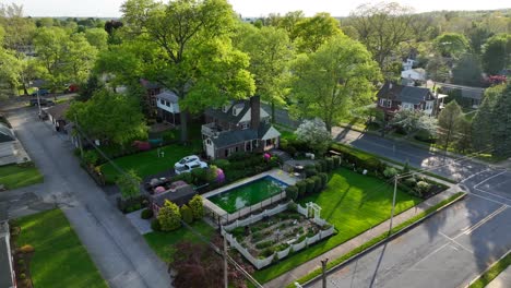 una lenta toma descendente cinematográfica de una piscina sentada en un jardín de una propiedad de casa bien cuidada y ajardinada en los estados unidos