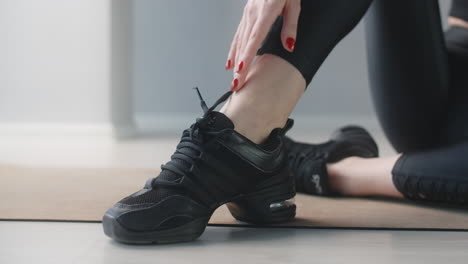 woman tying dance shoes