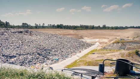 static panoramic view of a landfill with birds looking for food