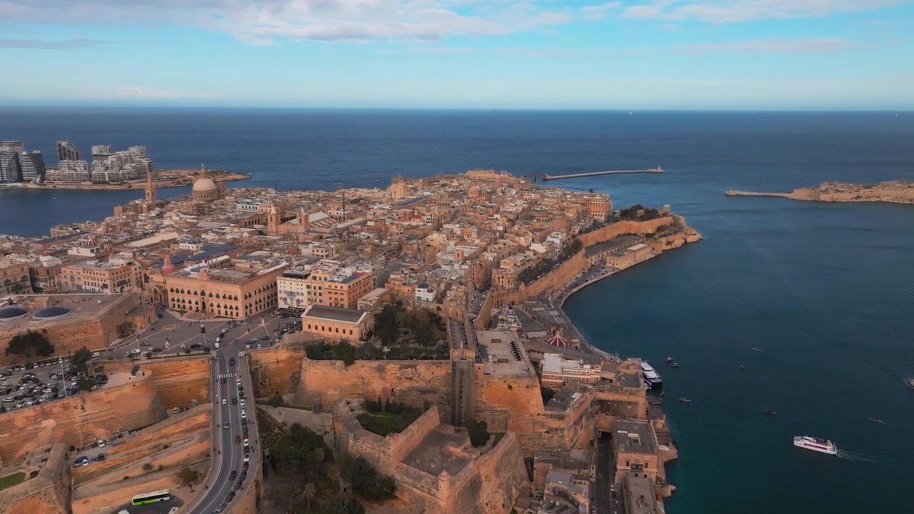 Bredt luftfoto af en kystby med en travl havn om dagen. Valletta, Malta.