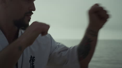 Man-exercising-martial-arts-at-sunset-closeup.-Athlete-practicing-karate-punches