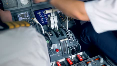 one airman is pointing at something on a screen in a cockpit