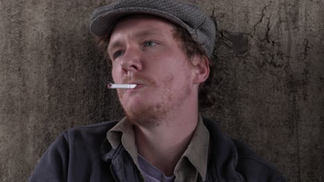 Close-Up-of-a-Homeless-Young-Adult-Male-Lighting-and-Smoking-a-Cigarette-In-Despair