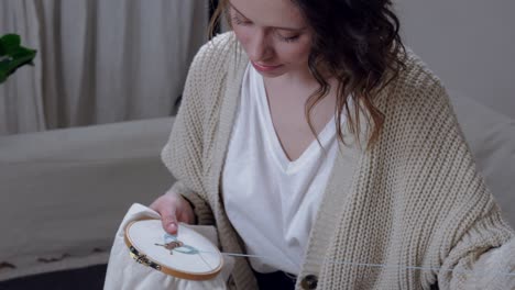 woman sewing in comforts of her apartment