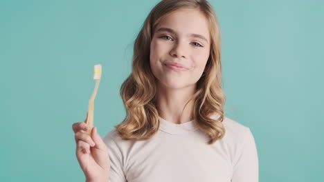 teenage caucasian girl in pijamas holding toothbrush.