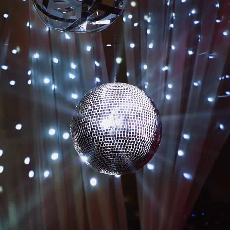 silver shining disco ball. mirror ball hanging from the ceiling and spinning against beautiful lights. entertainment concept.