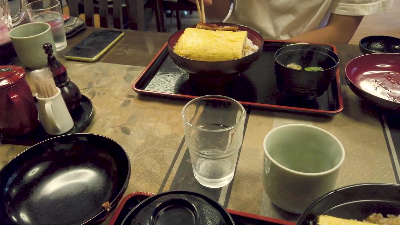 Mesa de pratos em restaurante tradicional japonês servida com Unagi don e ovo.