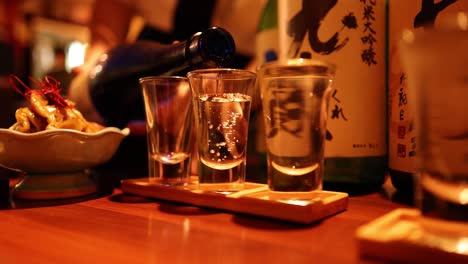 sake pouring into glass at a bar