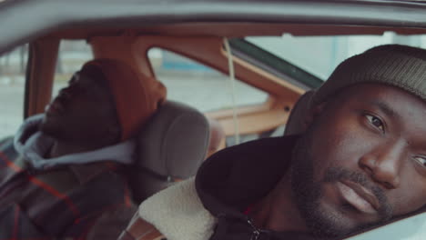 pensive african american man sitting in car