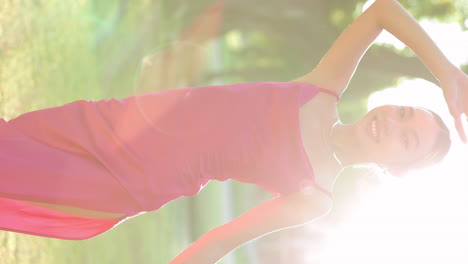 joyful woman in pink dress bathed in sunlight outdoors