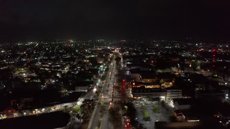 Nachts-Fliegen-Stürmer-über-Der-Großstadt.-Mehrspurige-Straße,-Die-Durch-Städtische-Nachbarschaft-In-Flacher-Landschaft-Führt.-Cancun,-Mexico