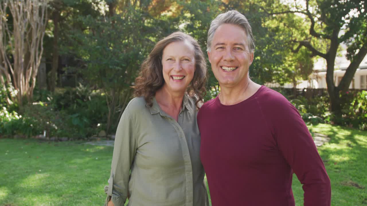 porträt eines glücklichen älteren kaukasischen paares, das im garten umarmt und lächelt