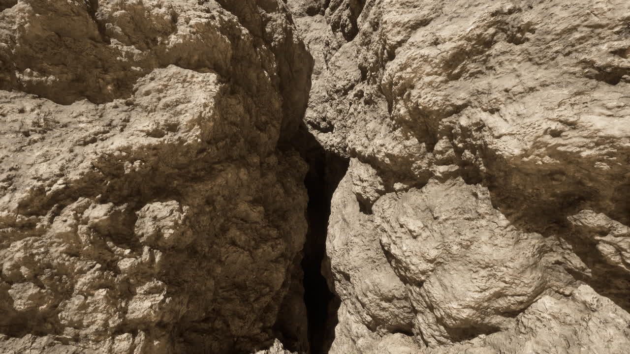 두 개의 거친 바위 벽 사이의 어두운 균열의 클로즈업