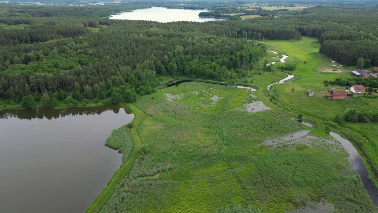 Drone flight over a village, view of lakes, forests, and marshlands