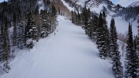 Skiers-and-Snowboarders-race-down-the-side-of-a-snow-packed-mountain-side-in-Utah