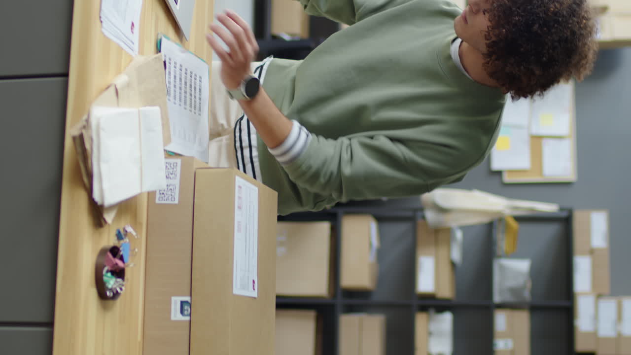 Worker Scanning Parcels in Delivery Service Office