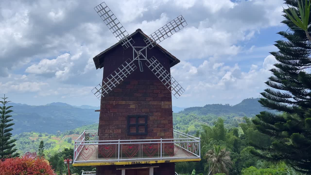 Charming brick windmill framed by rolling hills and cloudy sky—ideal for travel, nature, and scenic projects