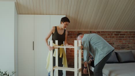 couple assembling wooden shelves