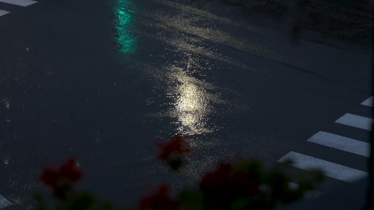 발코니에서 쏜 여름 폭풍우 아래 교차로를 지나가는 자동차