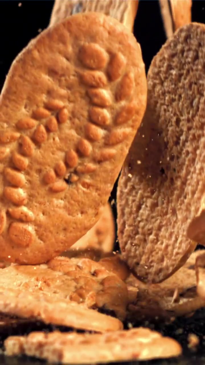 Golden Biscuits Falling in Slow Motion on a Black Background