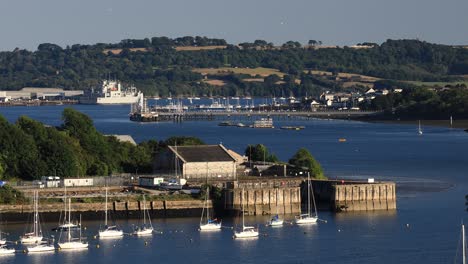 the river tamar with a view of torpoint in the distance with plymouth dockyard and yachts on the water between devon and cornwall