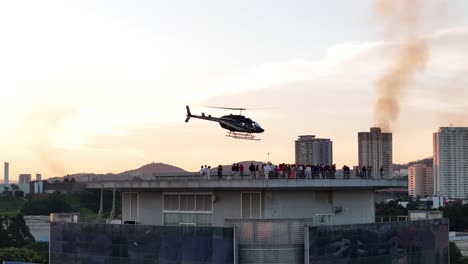 helicopter landing on rooftop during sunset party