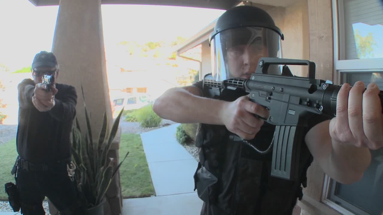 oficiales de la dea con los brazos en alto realizan un allanamiento de drogas en una casa 3