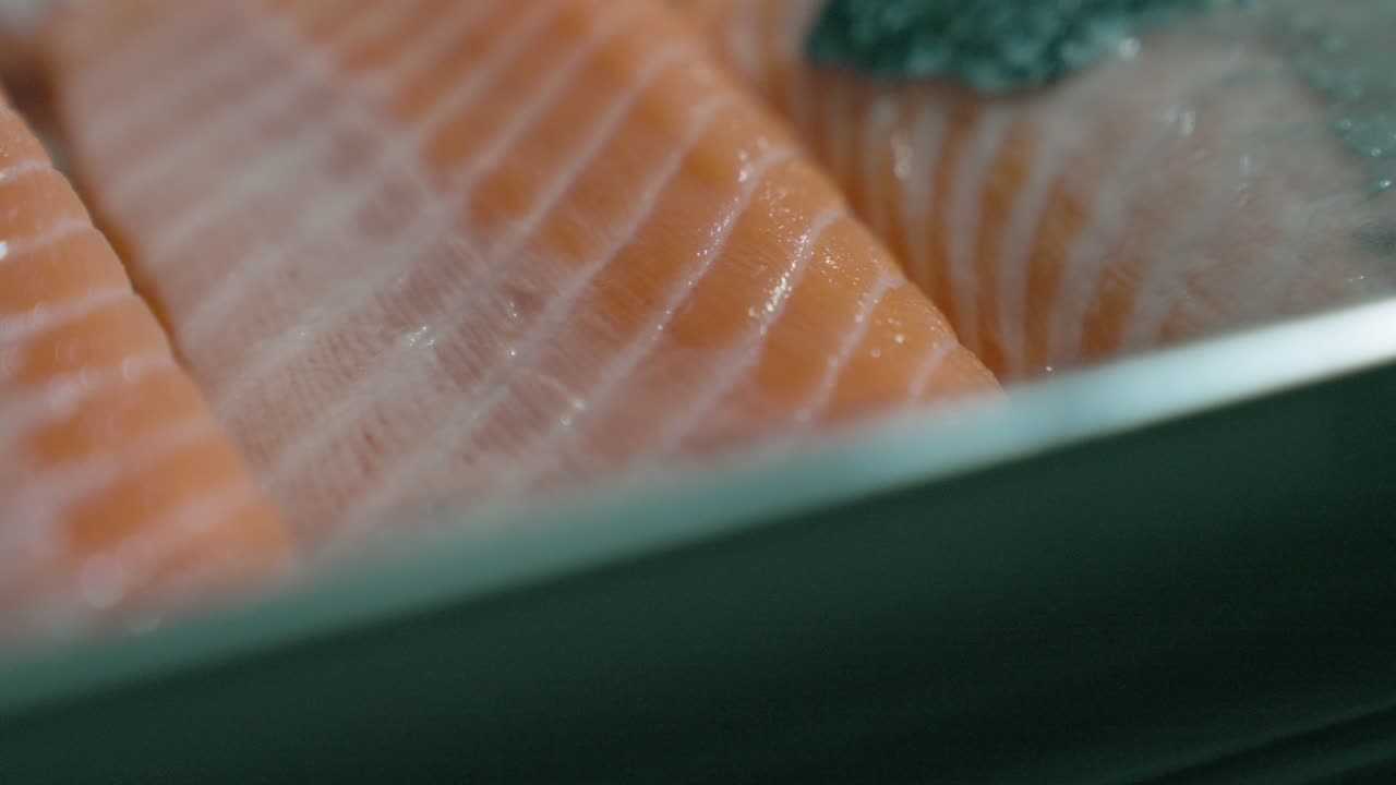 An up-close drop-down shot of raw fish, focusing on its fresh cuts, textures, and vibrant colors, perfect for showcasing fish preparation or seafood dishes.