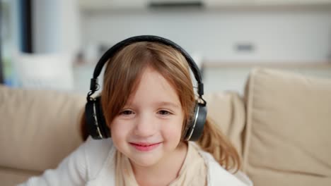 Retrato-De-Una-Niña-Feliz-Escuchando-Música-Inalámbrica-Con-Auriculares-En-La-Sala-De-Estar