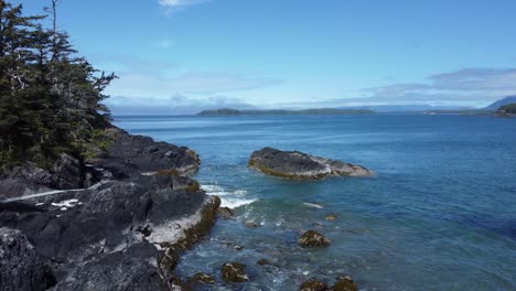 Costa-Rocosa-Con-Aguas-Azules-Claras-E-Islas-Distantes-Bajo-Un-Cielo-Brillante