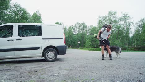 young and fit man wears his heavy backpack, going on a hike with c dog