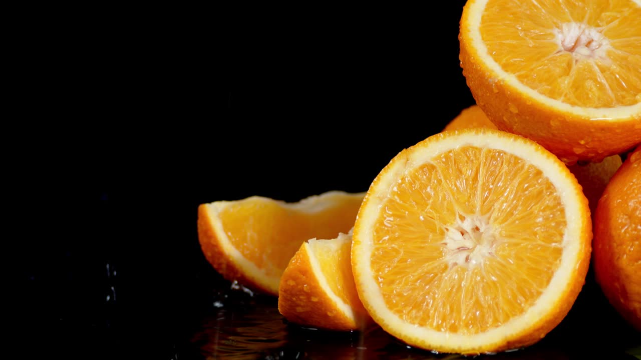 Pezzi di arancia succosa con gocce d'acqua che cadono