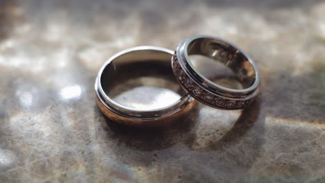 cool iridescent lights illuminate two golden rings. close-up shooting