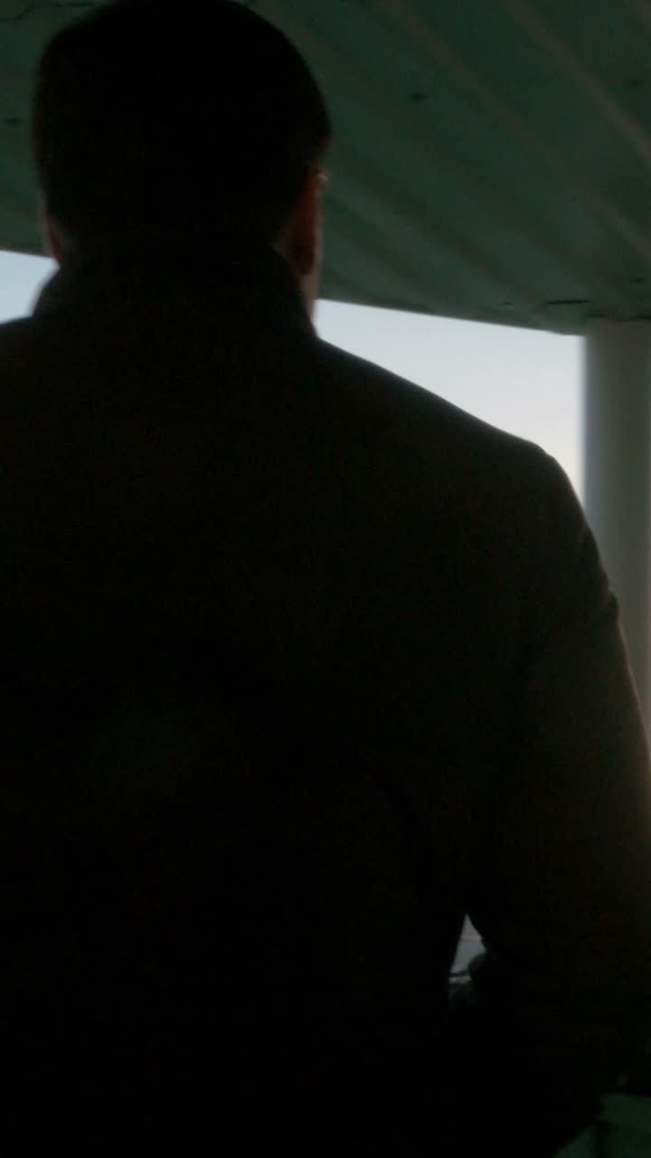 A man looking at the sea at sunset