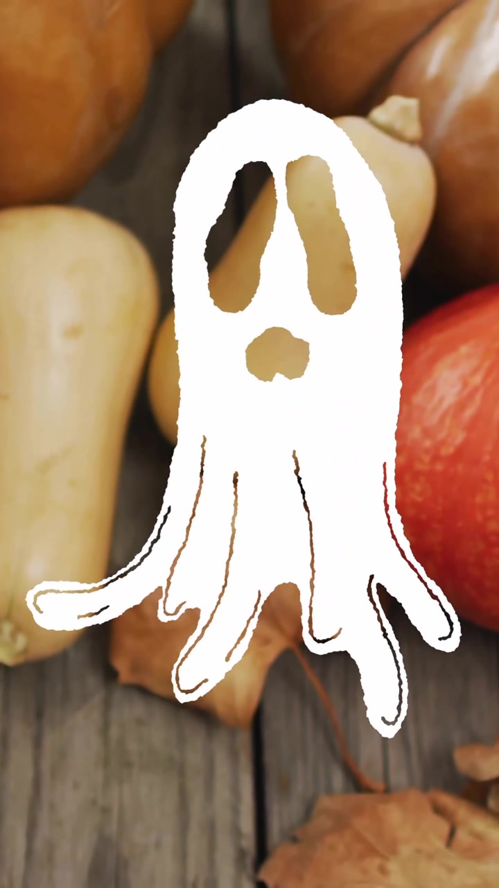 Animazione di un fantasma su zucche e foglie autunnali su una superficie di legno.