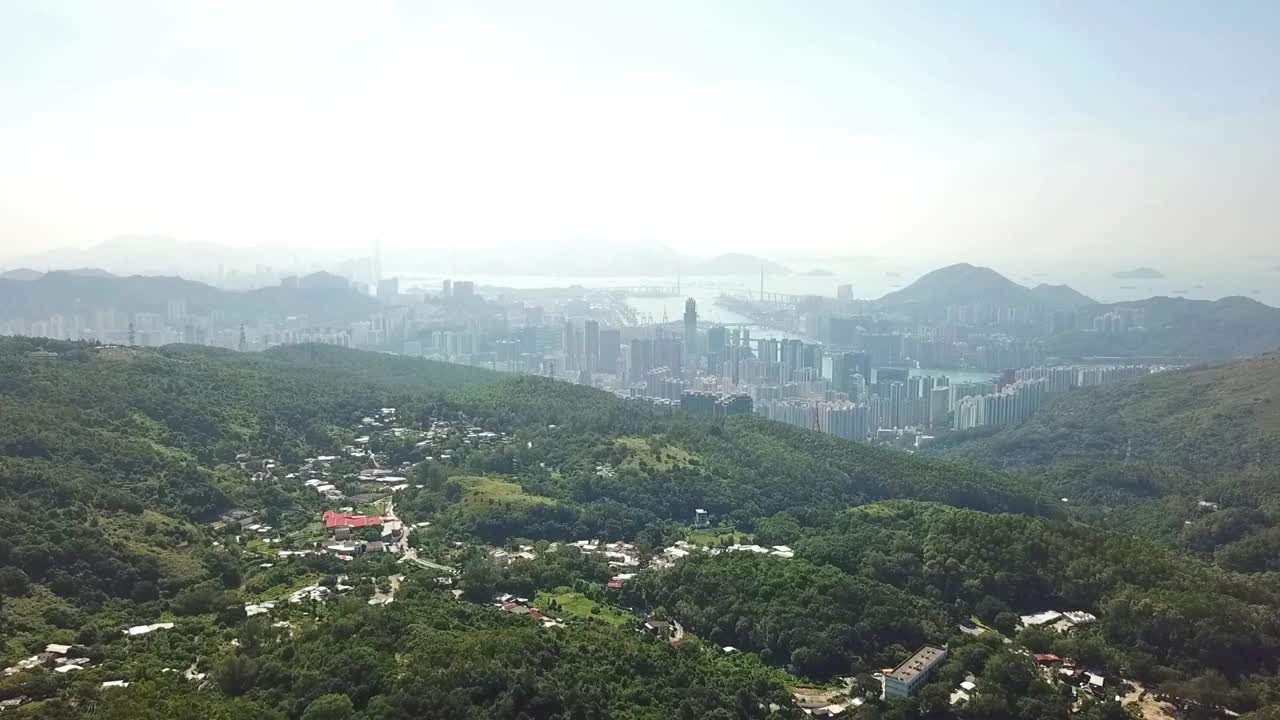 toma aérea, volando desde la jungla a la ajetreada ciudad de hong kong